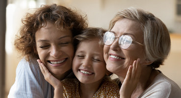 3 generations of smiling women representing discovery of medication reaction with the use of genetic testing